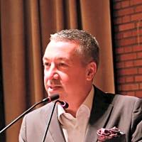 Speaker presenting at a conference, discussing the impact of human psyche on management practices and workplace dynamics.