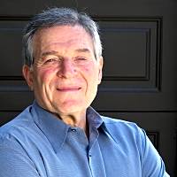 Smiling psychologist Larry Waldman stands confidently with crossed arms, promoting his mental health services in Scottsdale.