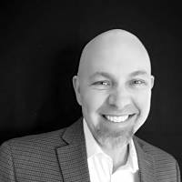 Jordan Price, Psychotherapist, Austin, United States A smiling professional in a suit, representing a commitment to personal and professional growth in therapy.