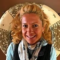 Therapist smiling warmly with a life preserver background, promoting children's mental health and coping strategies.