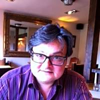 British-Polish psychotherapist in a restaurant, reflecting on systemic approaches in therapy and communication patterns.