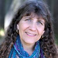 Friendly psychotherapist with long hair and a scarf, emphasizing the importance of career breaks for stress relief.