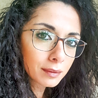 Qualified Child Psychotherapist Pia Tohme Khalaf with curly hair and glasses, based in Zalka, Beirut, Lebanon.