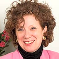 As Psychologist/ Psychoanalyst I wear 2 hats. 1st, over 40 years I've worked with individuals, families, couples (using PACT). 2nd, as a Divorce Mediator I consult with couples RE: Steps of Separation, & specialize in helping couples decide to Stay (& work on their relationship) OR to Separate (& how to leave). Smiling woman with curly hair wearing a pink jacket, reflecting on personal growth during a therapy session about loneliness.