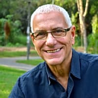 Smiling older man with glasses in a park, emphasizing the importance of personal growth in troubled marriages.
