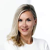 Professional woman smiling while wearing a white top, emphasizing a calm demeanor suitable for discussing mindful separation with children.
