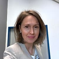 A compassionate psychologist, therapist working with individuals on emotional related disorders, stress and burnout, eating issues. Working as a Christian Psychologist (Seelsorge). Alt text: 'Ms. Salimova, a psychologist from Baar, Switzerland, poses with a neutral background, emphasizing her commitment to mental health.'