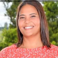Smiling woman in a red floral dress, representing emotional regulation and nurturing relationships with children.