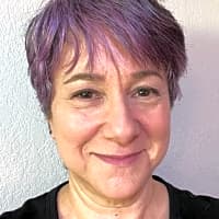 Is your inner critic relentless, driving you on a never ending quest to prove your worth? This part of you may seem like a bully, but it’s really a scared little kid. My superpower is teaching people how to listen to the fear, soothe it, and let self compassion lead them to true happiness. Professional woman with short purple hair smiling, representing a therapist specializing in mental health support and self-worth.