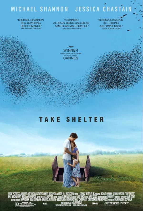 Movie poster for Take Shelter, featuring Michael Shannon and Jessica Chastain embracing near a stormy sky filled with birds.