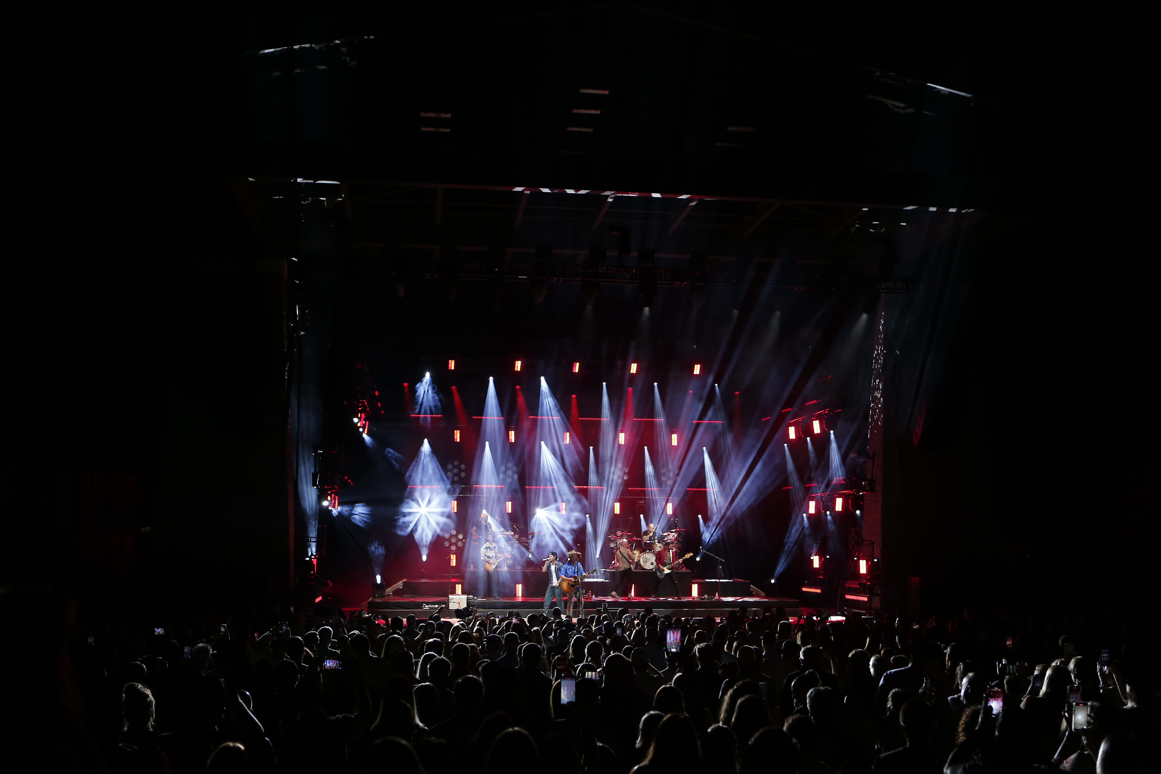 Vibrant festival atmosphere with colorful stage lights and excited crowd at a KNS Entertainment event