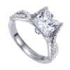 A princess cut center diamond sits in the middle of criss cross split shank bands, all covered in round brilliant diamonds in this platinum criss cross engagement ring. - Image 3 of 0