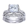 A princess cut center diamond sits in the middle of criss cross split shank bands, all covered in round brilliant diamonds in this platinum criss cross engagement ring. - Image 5 of 0