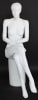 Seated white female mannequin with molded hair, matte fiberglass finish, and crossed-leg pose for apparel displays - Image 1 of 0