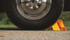 The Camco (44492) Super Wheel Chock is a single, large, yellow wheel chock made of durable plastic designed to keep a trailer securely in place. It is suitable for use with tires up to 29 inches in diameter. - Image 3 of 0