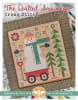 The Quilted Snowman CROSS STITCH Pattern  from It's Sew Emma shows a large snowman riding in a red wagon,  with a blue stocking cap, blue mittons and a blue scarf along with winter pines and scenery. - Image 1 of 0