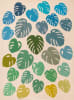 Monstera Quilt Pattern by Laundry Basket Quilt shows giant Monstera  plant leaf in various sizes and colors, on a contrasting light background. - Image 1 of 0