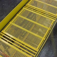 Yellow safety pit cover with durable metal grating for quick lube shops, offering a non-slip surface and enhanced visibility in busy maintenance areas