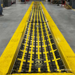 Yellow and black pit cover safety net with 'Caution No Step' warning at an automotive quick lube bay, ensuring safety around the service pit.