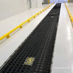 Quick lube oil change pit with PBSCÂ® Channel System pit covers, caution sign, and yellow safety rails.