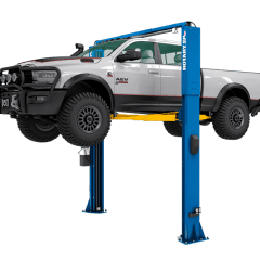 Rotary SPO12-AV 12,000 lb. capacity two-post lift raising a silver RAM 2500 heavy-duty pickup truck. The image showcases the blue Double S columns and yellow All-Vehicle (AV) arms, designed for high-ground-clearance trucks and EVs.