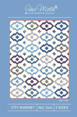 Citi Market Quilt Pattern by Gina Martinshows a picture of the quilt design sewn in blue, multicolor and cream colored fabrics,  in a repetitive tile grid.