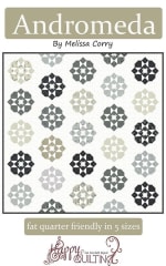 Bright colorful quilt features a bright star on a white ground for half the block, and bright colorful squares and half square triangles making up the other half of the block.