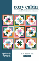 This is a very graphic quilt design with a center star surrounded by half square triangles in bright pinks, red and orange on a white ground.