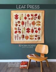 Leaf Press Quilt Pattern by Robin Pickens shows a dramatic wall hanging quilt in an array of fall colors and it just screams "FALL" in scrappy variations of reds, golds and browns.