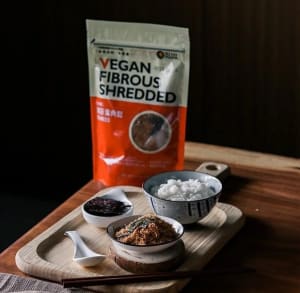 Vegan shredded mushroom fluff in a bowl with rice and bread