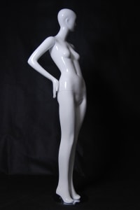 Tall standing female abstract mannequin in a glossy white fiberglass finish with a silver metal base.