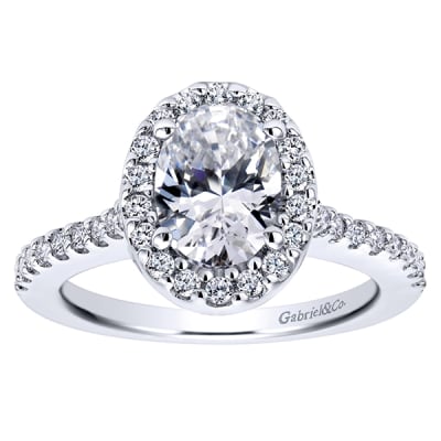 Round brilliant diamonds climb their way up this white gold or platinum band to form a diamond halo surrounding an oval cut diamond of your choice in this diamond oval halo engagement ring!