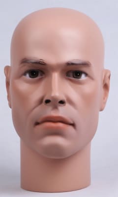 Realistic flesh-colored male display head with brown eyes flat base and fiberglass resin construction for headgear display