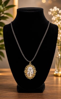 Handmade gold pendant necklace with genuine python skin inlay displayed on a black velvet jewelry stand.