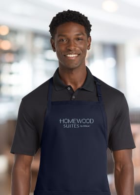 Restaurant-standard 65/35 poly/cotton twill bib apron. Durable 7.5-ounce, sliding neck adjustment, three patch pockets. 30" w x 31". Impressively embroidered with the Homewood Suites logo.