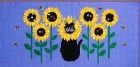 Sunflowers Abuzz Cat Quilt Pattern by Trouble & Boo shows a black cat in a sunflower patch.