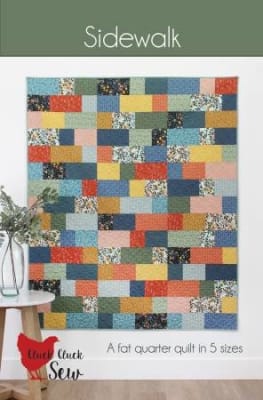 SIDEWALK Quilt Pattern by Cluck Cluck Sew shows a straight set quilt with colorful blocks  of small squares  and rectangles in bright colors side by side.
