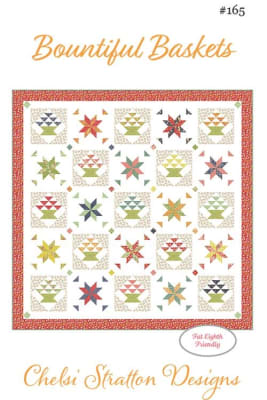 Bountiful Baskets  Quilt Pattern by Chelsi Stratton Designs shows a straight set quilt, with multiple different quilt blocks, including baskets and stars in scrappy colors.