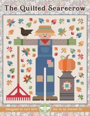 The Quilted Scarecrow Quilt Pattern from It's Sew Emma shows a scarecrow and fall iconagraphy such as a pumpkin, crows, and falling leaves in a multi-color design.