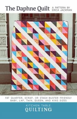 The Daphne Quilt Pattern by Kitchen Table Quilting shows a quilt with a diagonal quilt set of colorfuly pieced blocks.