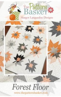 This quilt depicts graphic fall leaves as a quilt block, in a modern interpretation of grays and pumpkin , from The Pattern Basket