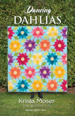 Dancing Dahlias Quilt Pattern by Krista Moser shows a colorful and brightly colored quilt with large star blocks.