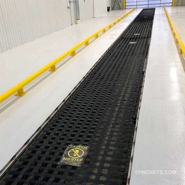 Quick lube oil change pit with PBSCÂ® Channel System pit covers, caution sign, and yellow safety rails.