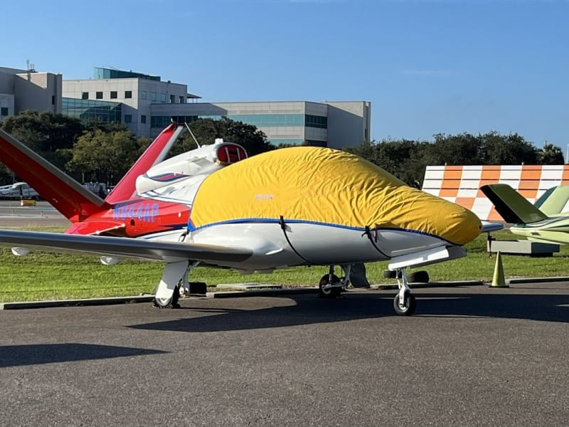 Silver Sunbrella Cirrus SF-50 Vision Jet canopy and nose cover with engine, prop, wing, and empennage protection installed outdoors.