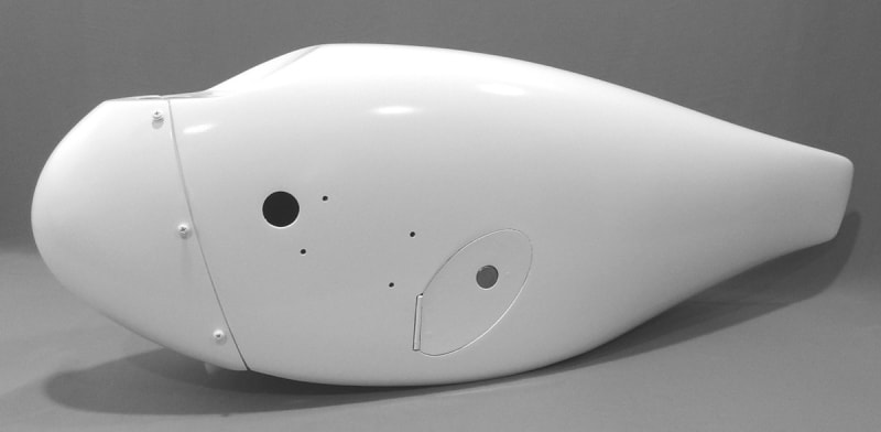 Carbon fiber nose wheel fairing for early model Cirrus SR20 and SR22 aircraft featuring integrated tire pressure access door, primed white.