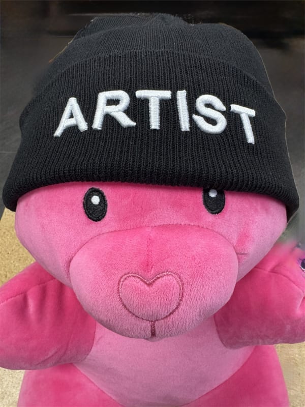 Helios Artist Beanie â€“ black knit hat with bold white â€œARTISTâ€ lettering, perfect for tattoo professionals