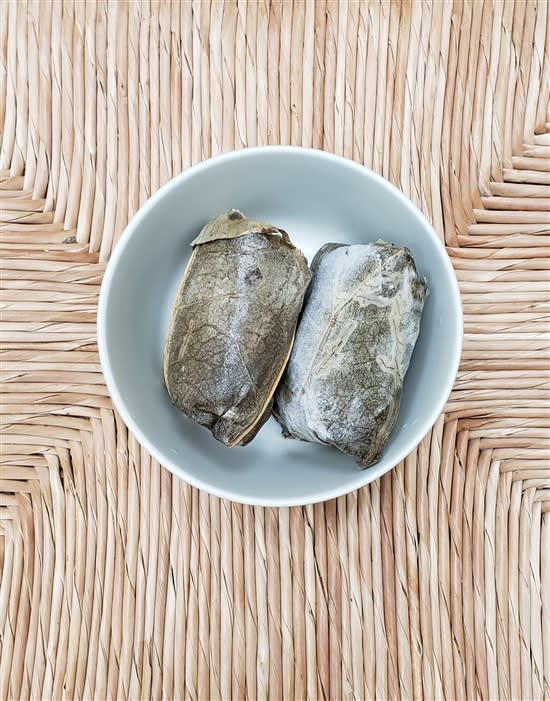 Buddha Bodai Vegan Sticky Rice Lotus Leaves, beautifully wrapped in lotus leaves, featuring fragrant sticky rice filled with a mix of vegetables and seasonings, elegantly presented on a plate, perfect for a flavorful and traditional plant-based dish.