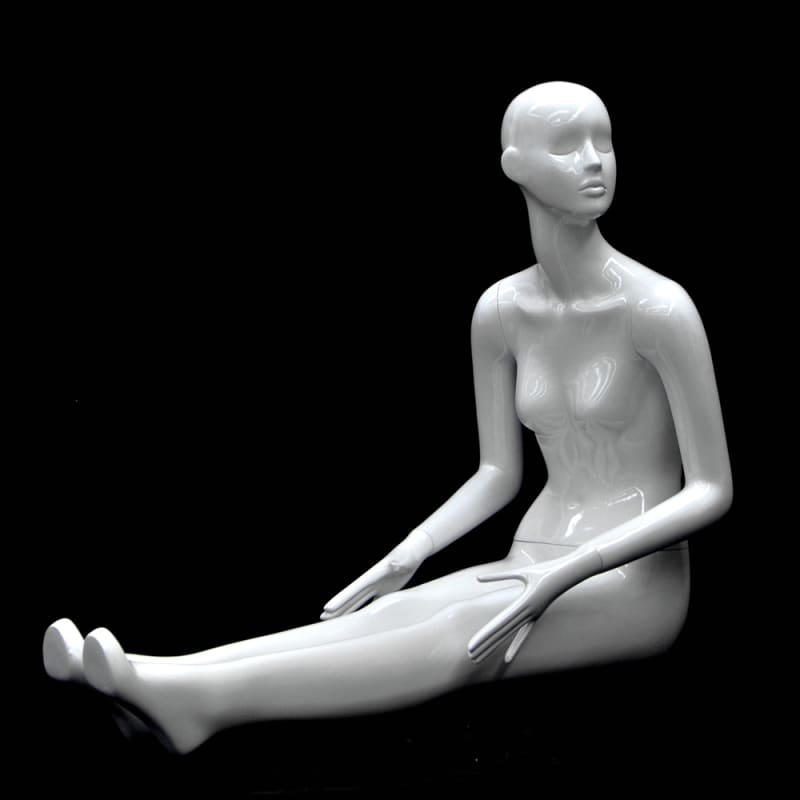 Seated abstract female mannequin in glossy white fiberglass with legs stretched out and no base required.
