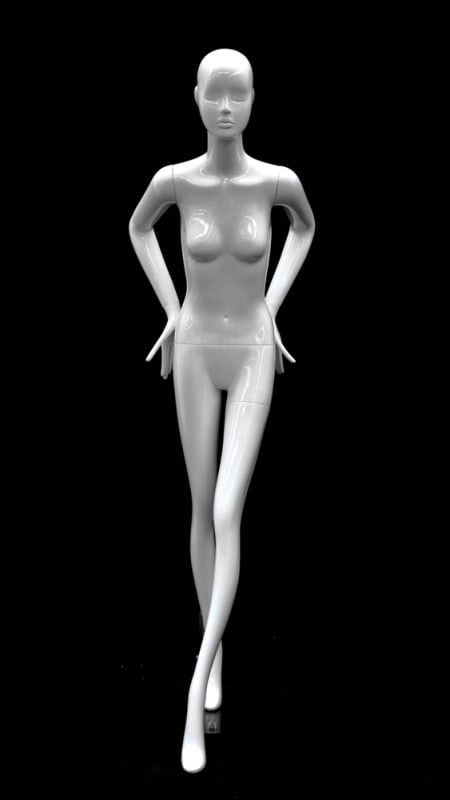 Abstract female mannequin in glossy white fiberglass leaning forward with arms behind back on a matching base.