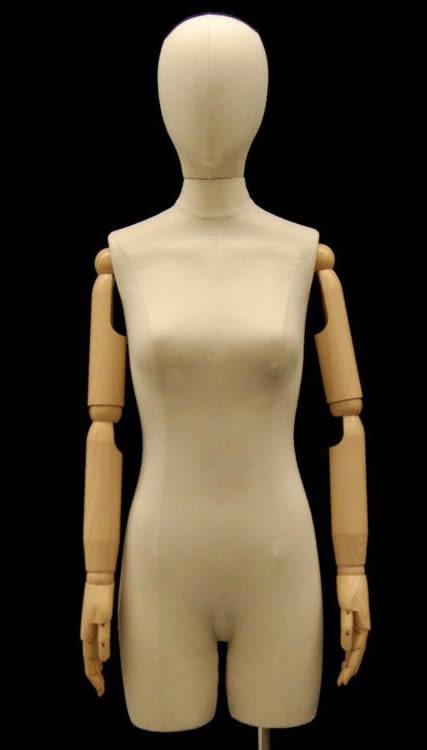 Pinnable female 3/4 dress form in tan linen with posable wood-look arms and a brushed metal offset floor base.